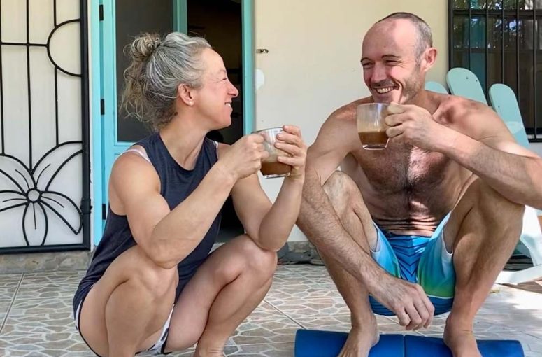 A couple engaging in a squatting position together, demonstrating an active effort to incorporate movement into their daily routine.