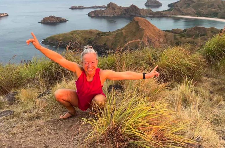 Woman is squatting in Padar Island, Indonesia.